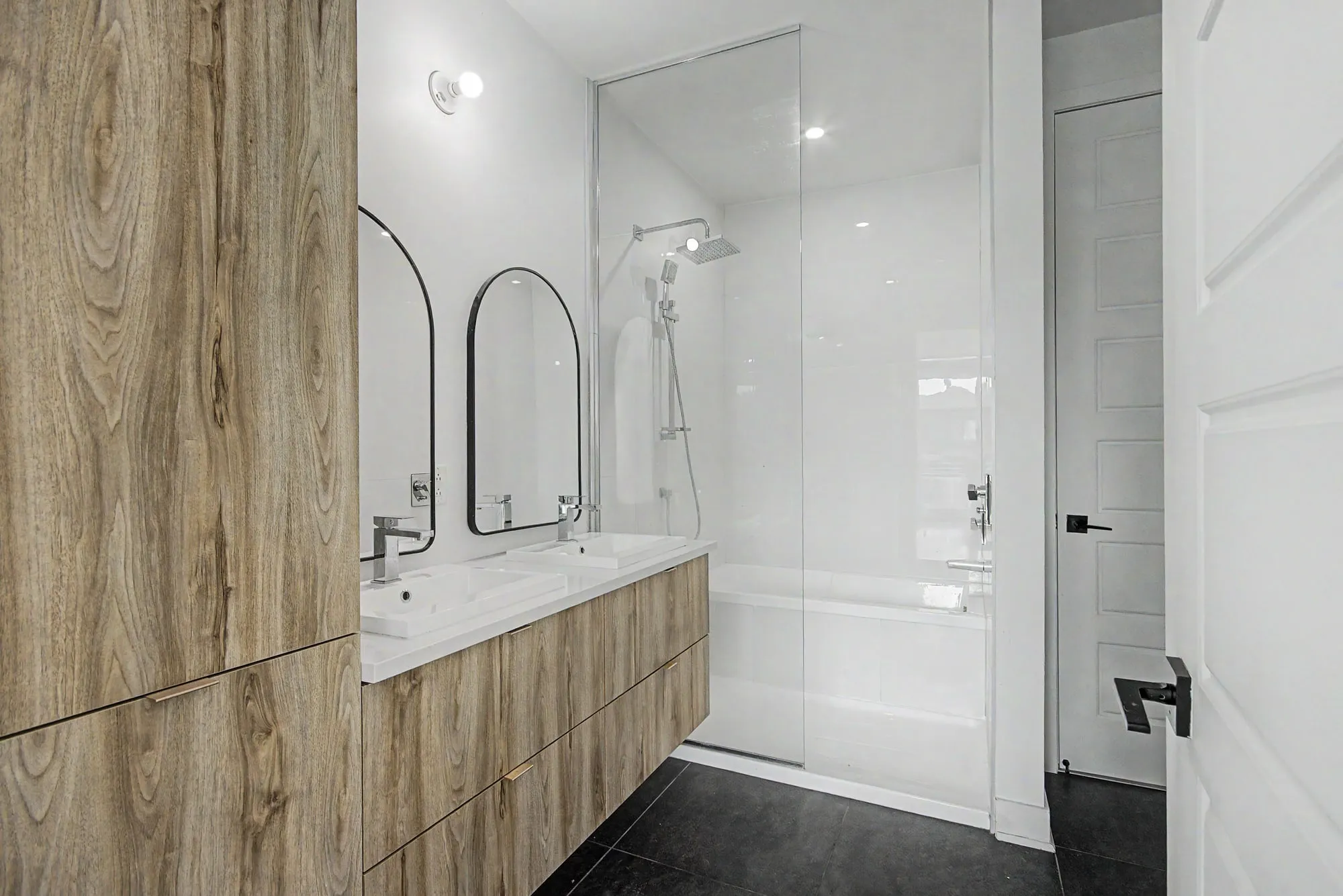 Salle de bain avec vanité en bois et douche vitrée