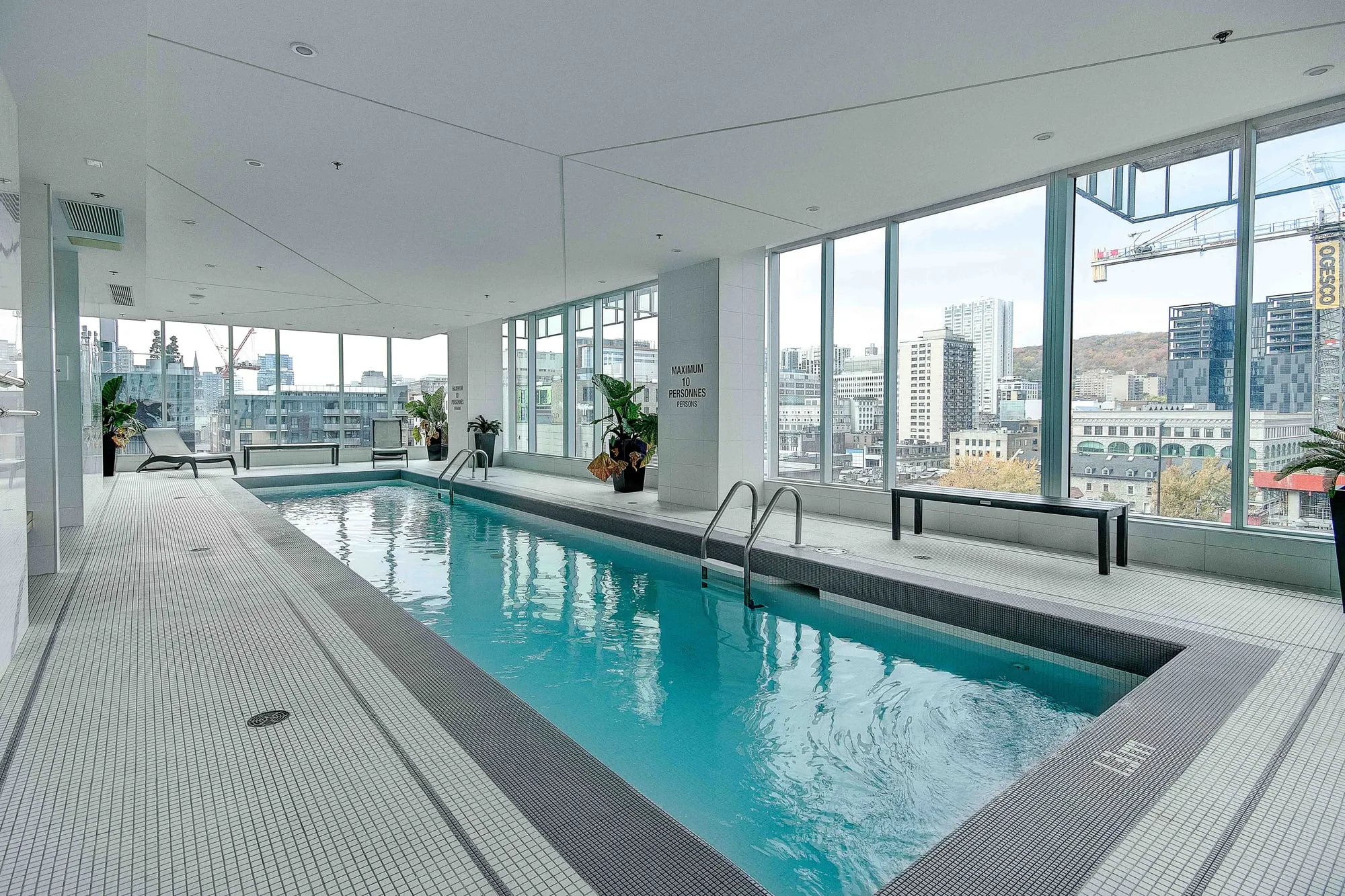 Piscine intérieure chauffée de l'immeuble avec vue sur la ville