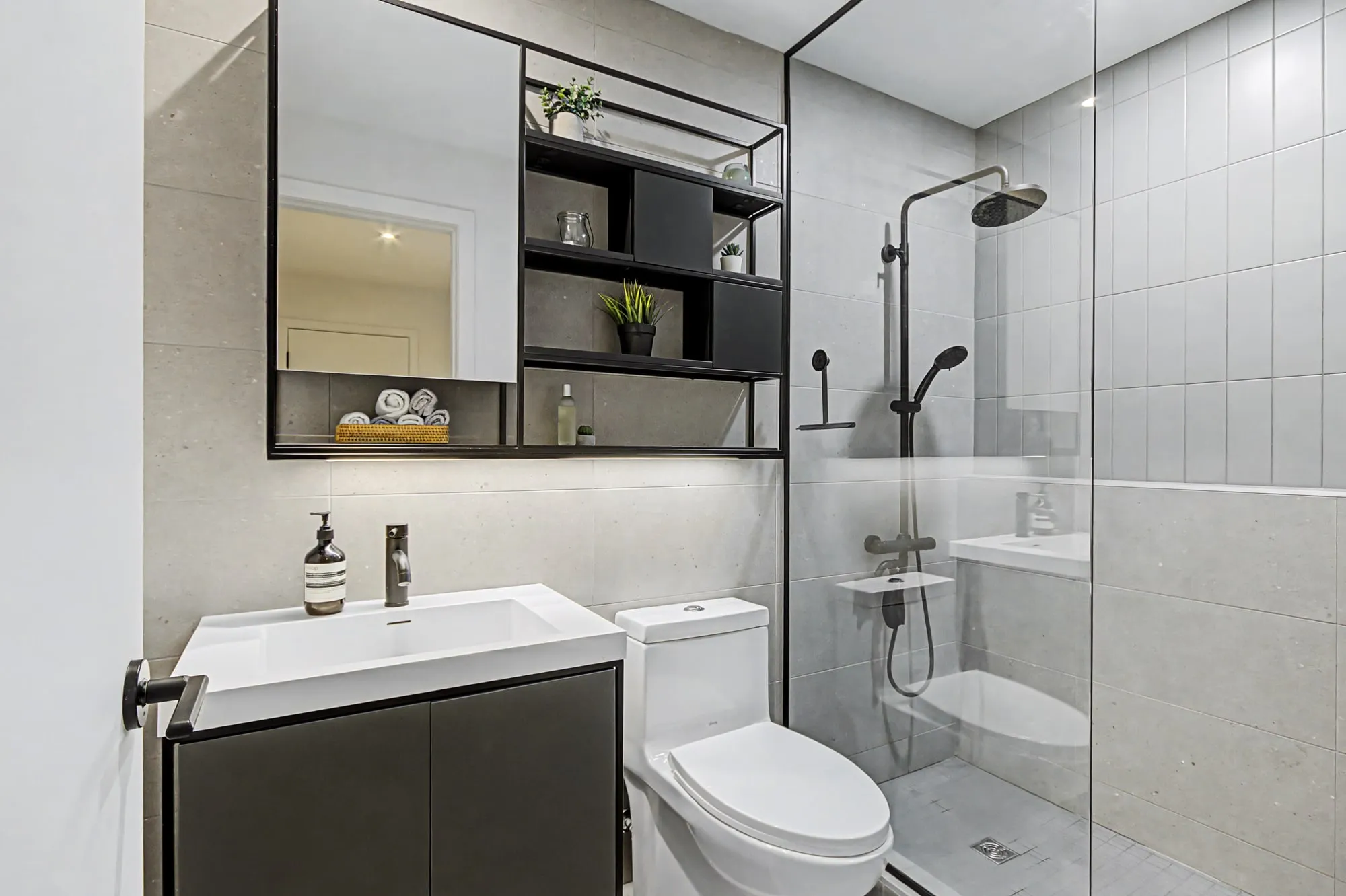 Salle de bain avec douche vitrée et rangement ouvert